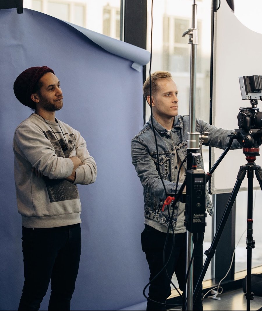 Erik on set during a photo and video shoot, arms crossed, wearing a beanie